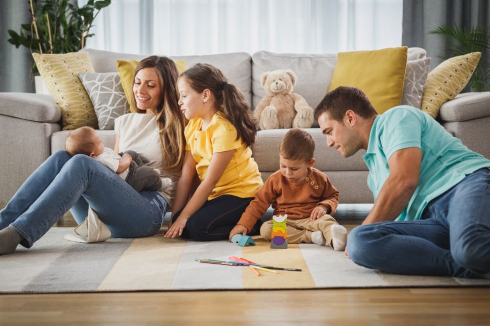 Familie spielt gemeinsam im Wohnzimmer